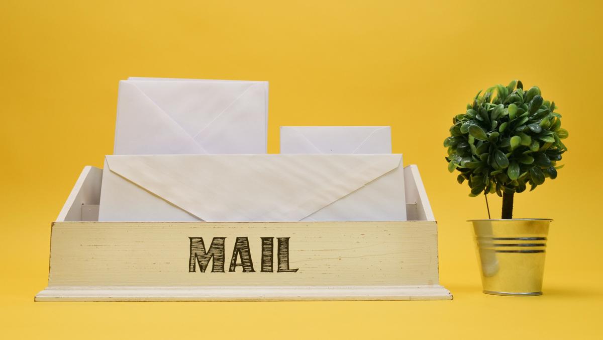 Ungeöffnete Briefumschläge in einer Postablage, Symbolbild für nach einer Reise gelesene Post